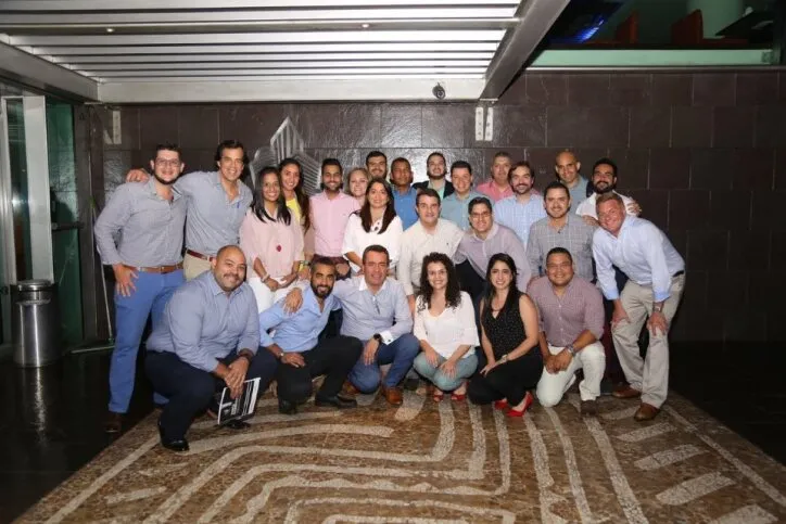 Grupo de profesionales sonriendo y posando juntos después de completar un curso de liderazgo intensivo